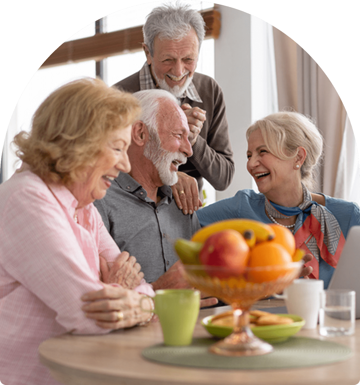 Elderly friends laughing around a table.