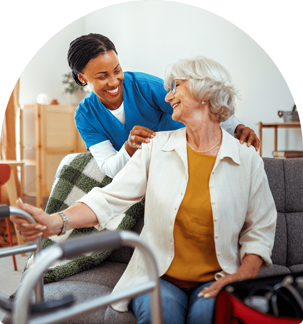 A caregiver warmly assists an elderly woman in a wheelchair.