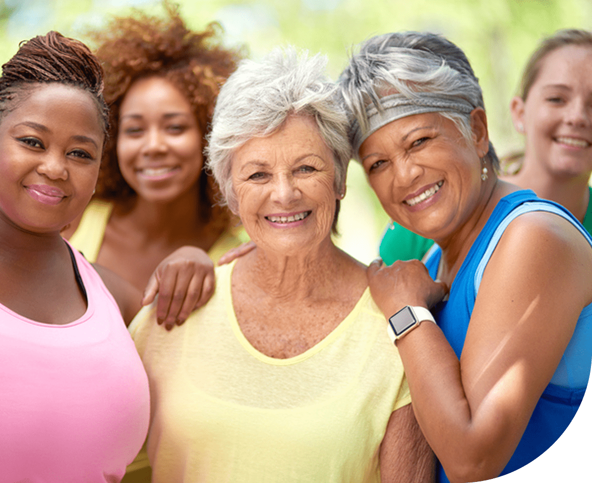 Group of smiling women outdoors, diverse ages.