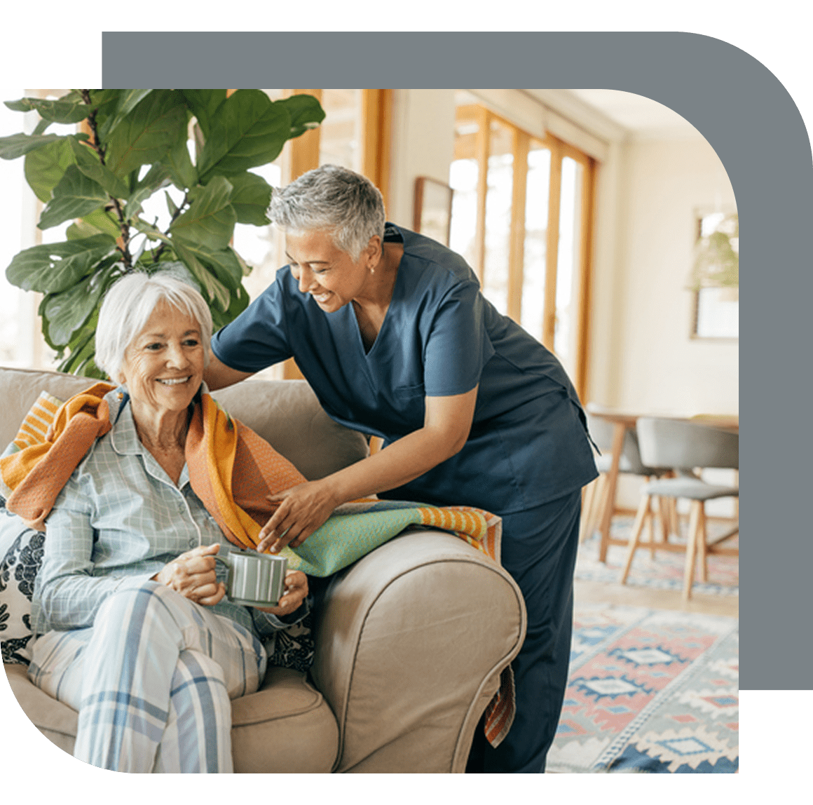 Caregiver assisting elderly woman on couch.